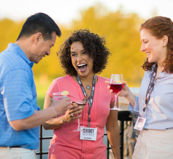 Meeting guests standing on terrace with wine laughing